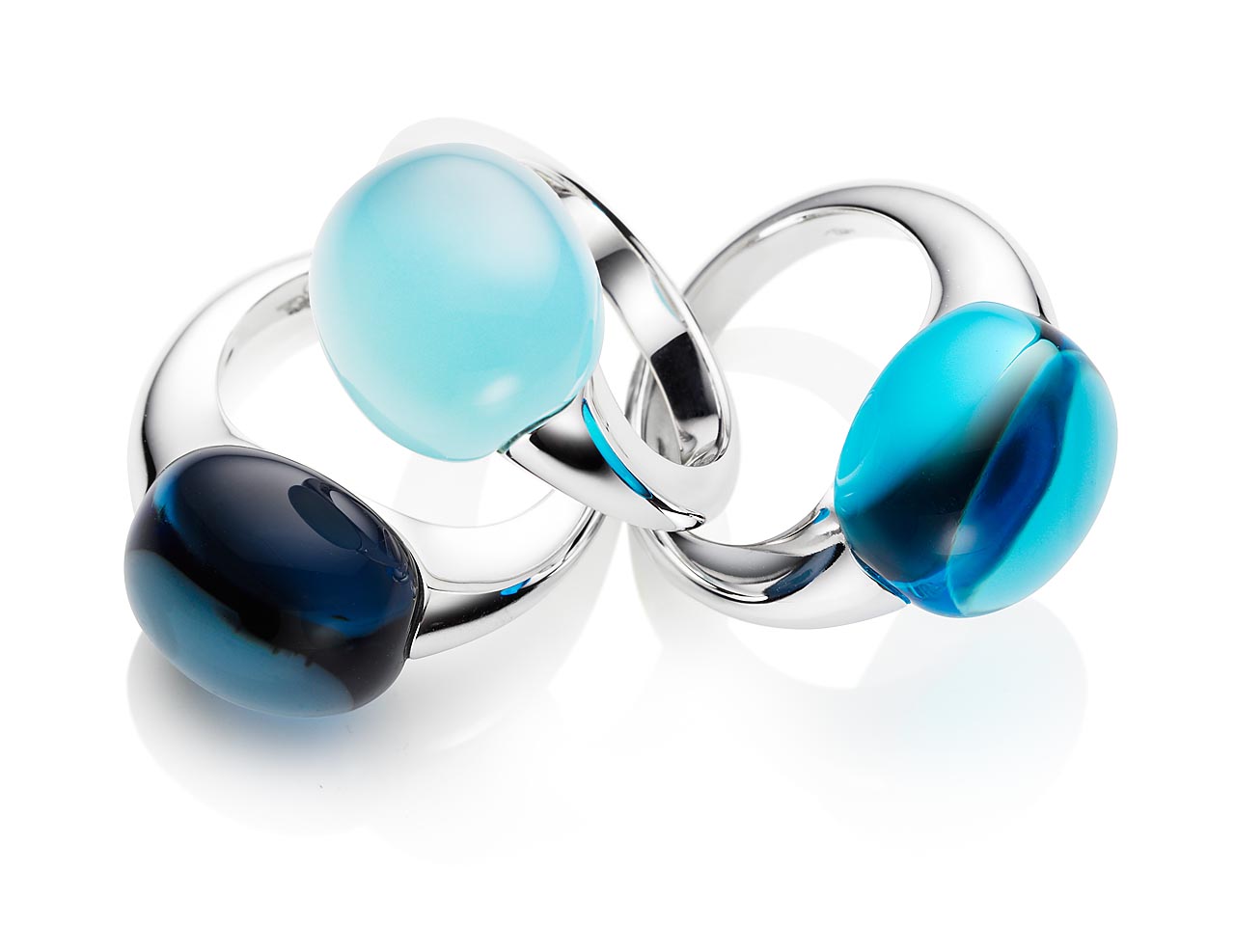 Sachaufnahme im Studio von drei Ringen weißgold mit blauen Farbsteinen auf weißem Untergrund
